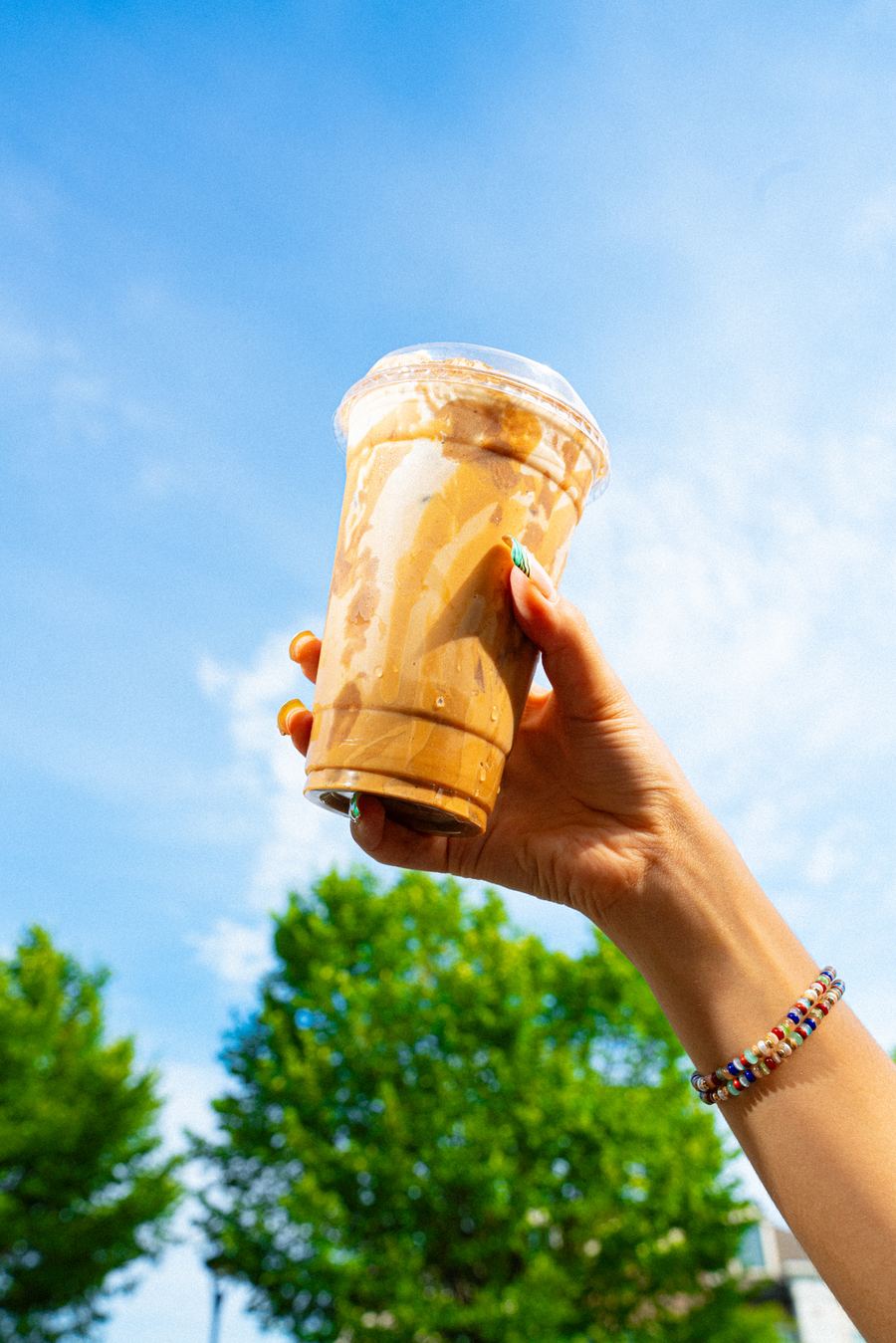 BITE — iced caramel latte against the sky